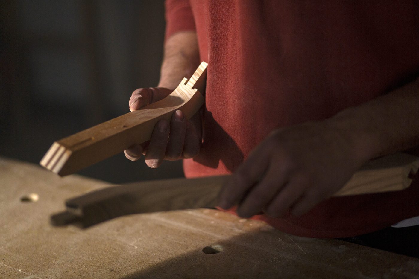A maker at the bench, close on the hand and the wood